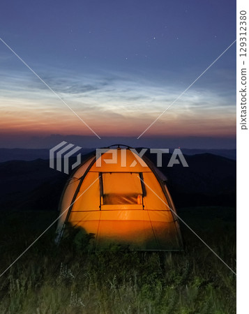 Camping at dusk. Vertical view. 129312380