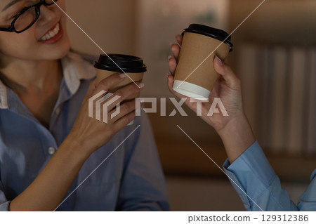 Team Collaboration. Colleagues toasting with coffee cups in office. 129312386
