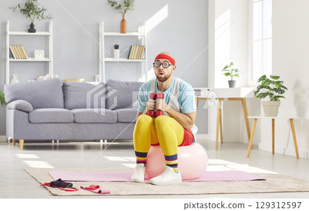 Funny Beginner Man In Retro Sportswear And Glasses Exercising At Home 129312597