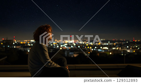 A man looking at the neon lights at dusk A man looking at the neon lights at dusk 129312893