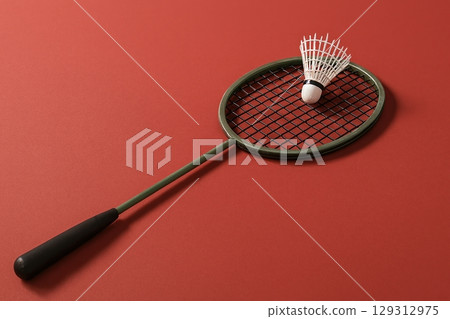 Badminton racket with shuttlecock on red background in minimal composition 129312975
