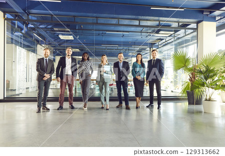 Confident diverse professional business team standing in modern office looking at camera 129313662