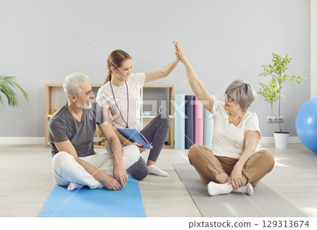 Physiotherapist High-Fiving Senior Couple During Rehabilitation Physiotherapist High-Fiving Senior Couple During Rehabilitation 129313674