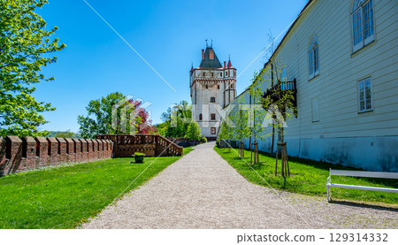 White Tower near Hradec nad Moravici Chateau in the Czech Republic, standing tall against the sky. Its striking white color contrasts with the surrounding greenery and historical buildings. White Tower near Hradec nad Moravici Chateau in the Czech Republic, standing tall against the sky. Its striking white color contrasts with the surrounding greenery and historical buildings. 129314332