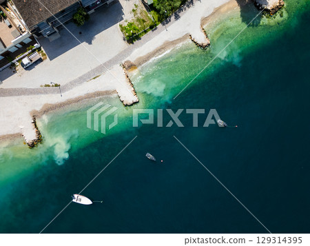 Aerial drone view of Lago di Garda (lake Garda) coastline, Italy. The beach and fresh blue water. 129314395