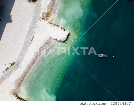 Aerial drone view of Lago di Garda (lake Garda) coastline, Italy. The beach and fresh blue water. Aerial drone view of Lago di Garda (lake Garda) coastline, Italy. The beach and fresh blue water. 129314397