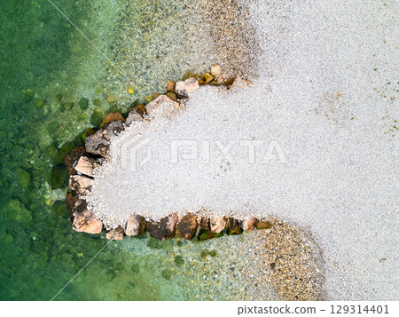 Aerial drone view of Lago di Garda (lake Garda) coastline, Italy. The beach and fresh blue water. Aerial drone view of Lago di Garda (lake Garda) coastline, Italy. The beach and fresh blue water. 129314401