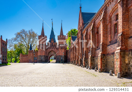 Entrance gate and stone walls of Hradec nad Moravici Castle in the Czech Republic, showcasing Gothic revival architecture surrounded by greenery in a peaceful historic setting. Entrance gate and stone walls of Hradec nad Moravici Castle in the Czech Republic, showcasing Gothic revival architecture surrounded by greenery in a peaceful historic setting. 129314431
