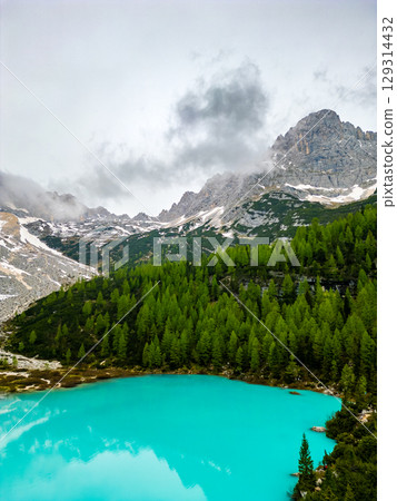 Aerial drone view of beautiful Lake Sorapis, Lago di Sorapis, in Dolomites, popular travel destination in Italy. Blue green lake in Italian Dolomites 129314432