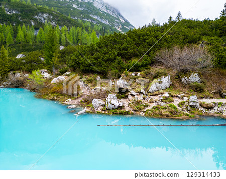 Aerial drone view of beautiful Lake Sorapis, Lago di Sorapis, in Dolomites, popular travel destination in Italy. Blue green lake in Italian Dolomites Aerial drone view of beautiful Lake Sorapis, Lago di Sorapis, in Dolomites, popular travel destination in Italy. Blue green lake in Italian Dolomites 129314433