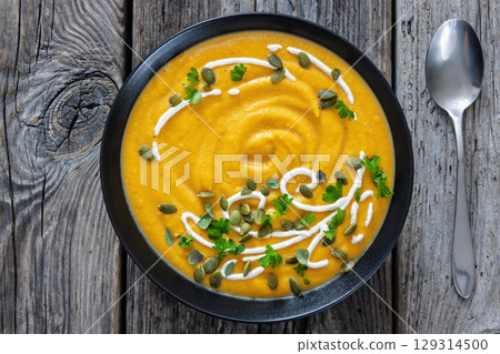 roasted pumpkin puree soup in a black bowl roasted pumpkin puree soup in a black bowl 129314500