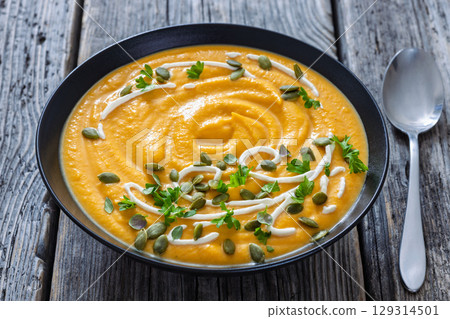 roasted pumpkin puree soup in a black bowl roasted pumpkin puree soup in a black bowl 129314501