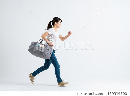 一名日本女子因快要錯過車而匆忙奔跑（白色背景，用於剪切） 129314700