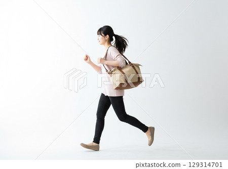 一名日本女子因快要錯過車而匆忙奔跑（白色背景，用於剪切） 129314701