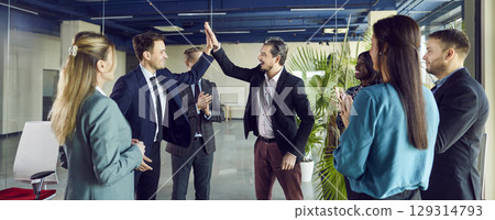 Business People Giving High Five And Celebrating Success In A Team Meeting 129314793