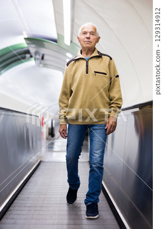 Old man going down to metro station 129314912