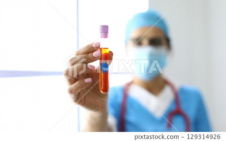 Medical professional holds a blood sample in a laboratory setting during daytime hours with a focus on health and research Medical professional holds a blood sample in a laboratory setting during daytime hours with a focus on health and research 129314926