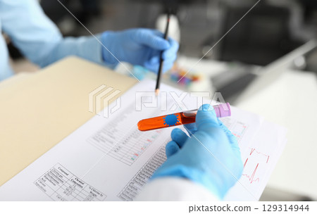 Laboratory technicians conducting tests in a modern lab setting with colorful samples and thorough documentation Laboratory technicians conducting tests in a modern lab setting with colorful samples and thorough documentation 129314944