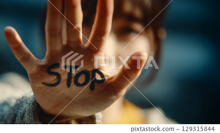Anti-violence concept with a young woman writing STOP on her palm 129315844