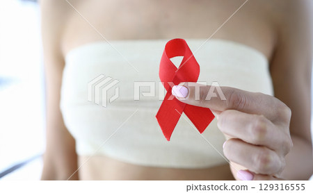 Supporting awareness through a red ribbon during a health initiative in the community on a sunny day Supporting awareness through a red ribbon during a health initiative in the community on a sunny day 129316555