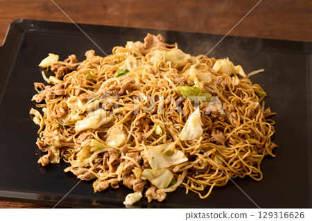 Cooking Yakisoba with Sauce on an Iron Plate 129316626