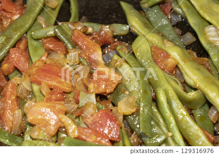 Fried green beans with tomato and onion pieces. Tasty meal with french bean on dinner or lunch on the pan Fried green beans with tomato and onion pieces. Tasty meal with french bean on dinner or lunch on the pan 129316976