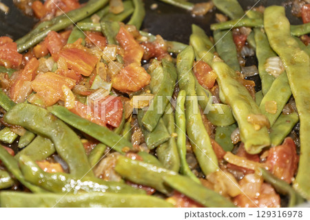 Fried green beans with tomato and onion pieces. Tasty meal with french bean on dinner or lunch on the pan Fried green beans with tomato and onion pieces. Tasty meal with french bean on dinner or lunch on the pan 129316978
