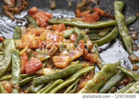 Fried green beans with tomato and onion pieces. Tasty meal with french bean on dinner or lunch on the pan 129316980