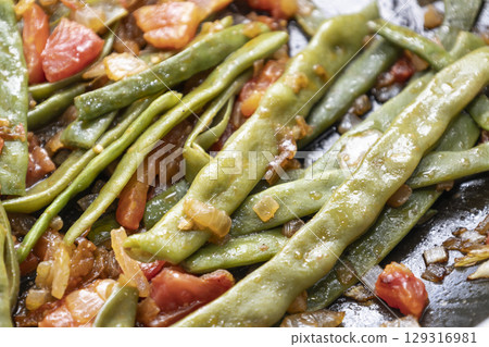 Fried green beans with tomato and onion pieces. Tasty meal with french bean on dinner or lunch on the pan Fried green beans with tomato and onion pieces. Tasty meal with french bean on dinner or lunch on the pan 129316981