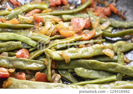 Fried green beans with tomato and onion pieces. Tasty meal with french bean on dinner or lunch on the pan 129316982