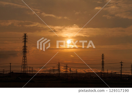 Landscape with a steel tower illuminated by the setting sun Landscape with a steel tower illuminated by the setting sun 129317190