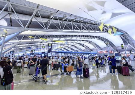 The international departure lobby at Kansai Airport is crowded with tourists. 129317439