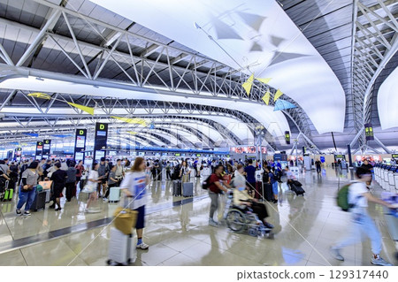 The international departure lobby at Kansai Airport is crowded with tourists. 129317440