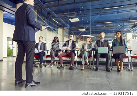 Male business coach speaker in suit giving presentation, speaker presenter consulting training Male business coach speaker in suit giving presentation, speaker presenter consulting training 129317512