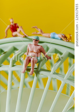 three beachgoers on a green fan three beachgoers on a green fan 129317655