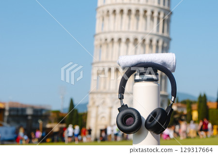 white bottle and headphones near Pisa Tower 129317664
