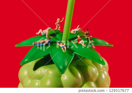 miniature holidaymakers on a fruit bottle miniature holidaymakers on a fruit bottle 129317677