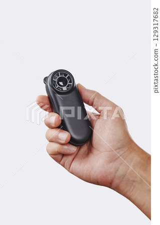 a man cools himself with a black handheld fan 129317682