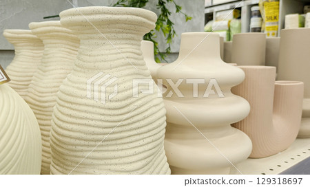 Various modern ceramic vases with speckled texture and different organic shapes on store shelf. Great for concepts of home decor, interior design and modern art 129318697