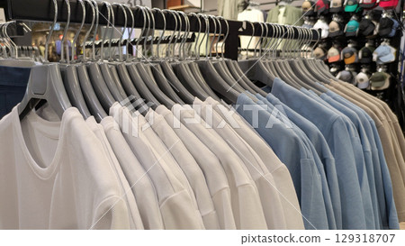 Long shot of clothing rack in store, displaying variety of different colored cotton t-shirts and tops Long shot of clothing rack in store, displaying variety of different colored cotton t-shirts and tops 129318707