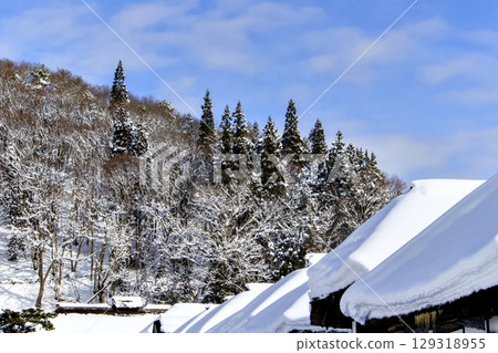 The view of the Japanese houses of Ouchijuku and the snow-covered mountains is beautiful. The view of the Japanese houses of Ouchijuku and the snow-covered mountains is beautiful. 129318955