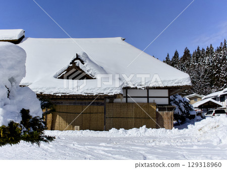 A view of a Japanese house in Ouchijuku covered in a lot of snow 129318960