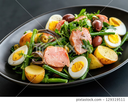 Tuna nicoise salad with green beans, potatoes, olives, hard-boiled eggs, and anchovies 129319511