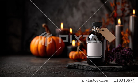 Mockup of black glass potion bottle with blank white label on Halloween theme background with copy space for text, dark black and orange color tone. 129319674