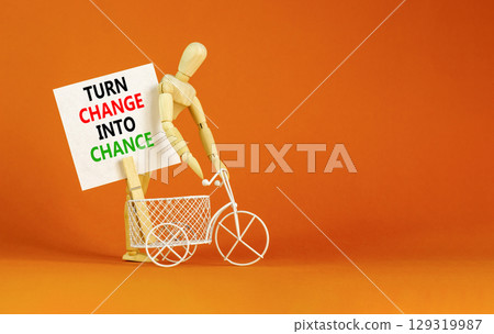 Turn change into chance symbol. Concept words phrase Turn change into chance on beautiful white paper on clothespin. Beautiful orange background. Business Turn change into chance concept. Copy space. 129319987