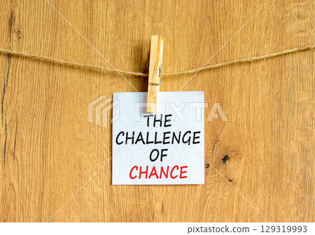 The challenge of chance symbol. Concept words phrase The challenge of chance on beautiful white paper on clothespin. Beautiful wooden background. Business The challenge of chance concept. Copy space. 129319993