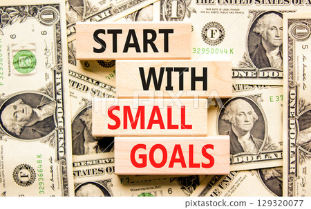 Start with small goals symbol. Concept words phrase Start with small goals on beautiful blocks. Dollar bills. Beautiful dollar bills background. Business Start with small goals concept. Copy space 129320077