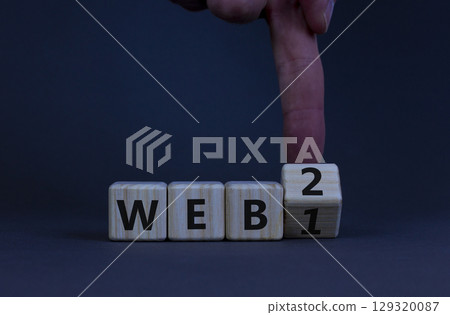WEB 1 or 2 symbol. Businessman turns a wooden cube and changes words WEB 1 to WEB 2. Beautiful grey table, grey background, copy space. Business, technology and WEB 1 or 2 concept. WEB 1 or 2 symbol. Businessman turns a wooden cube and changes words WEB 1 to WEB 2. Beautiful grey table, grey background, copy space. Business, technology and WEB 1 or 2 concept. 129320087