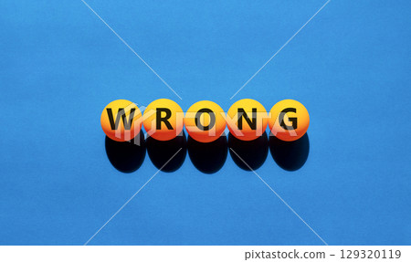 Wrong symbol. Concept word Wrong on beautiful yellow tennis ping pong balls. Beautiful wooden table wooden background. Business lifestyle wrong concept. Copy space. 129320119