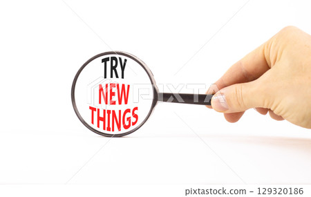 Try new things symbol. Concept words Try new things in beautiful magnifying glass. Beautiful white background. Businessman hand. Business motivational lifestyle try new things concept. Copy space. Try new things symbol. Concept words Try new things in beautiful magnifying glass. Beautiful white background. Businessman hand. Business motivational lifestyle try new things concept. Copy space. 129320186